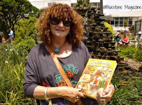 Claire Jennings still has the book she received as a child at one of the FJ Christmas Parties.  It inspired a life long interest in children's literature.  Claire is in the FJ gardens with her book at the 2015 community Christmas party in the gardens.  Photo:Bluestone Magazine